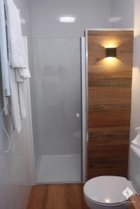 een badkamer met een toilet en een glazen douchedeur bij Dona Maria in Portalegre