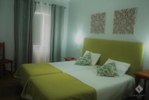 a bedroom with a large bed with two pillows at Dona Maria in Portalegre