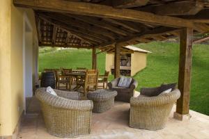 un patio con sedie in vimini e un tavolo in un cortile di Agriturismo Borgo Serafino a Mangone