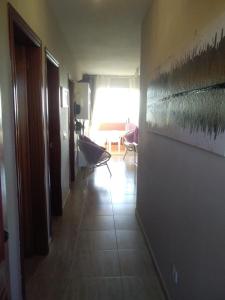 un pasillo con una habitación con sofá y ventana en REGINA VITTORIA, en La Oliva