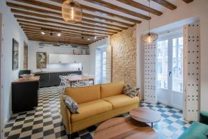 a living room with a couch and a kitchen at Apartamentos Son de Cadiz in Cádiz