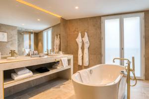 a bathroom with a tub and a large mirror at Maison Albar Hotels L’Imperator in Nîmes