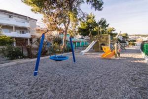 a playground with several slides and swings at Apartment Sunset in Trogir