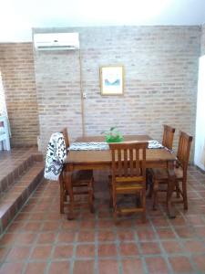una mesa de madera y sillas en una habitación en Casa Dos, casita de campo en Alta Gracia