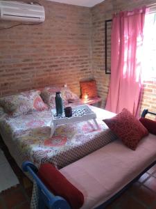 Un dormitorio con una cama con una mesa. en Casa Dos, casita de campo en Alta Gracia