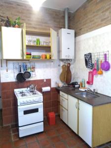 a kitchen with a stove and a counter top at Casa Dos, casita de campo in Alta Gracia