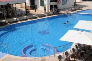 a man swimming in a large swimming pool at Minura Cala Galdana & Apartamentos d'Aljandar in Cala Galdana