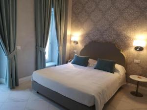ein Schlafzimmer mit einem großen Bett mit blauen Kissen in der Unterkunft Hotel Altavilla Catanzaro in Catanzaro