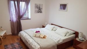 a bedroom with a bed with two books on it at Apartman Ivan in Senj