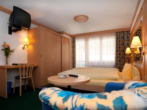 a hotel room with a bed and a table at Hotel Ambiente in Saas-Fee