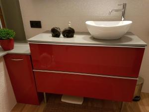 a bathroom with a red cabinet with a sink at Room Feliz in Zele