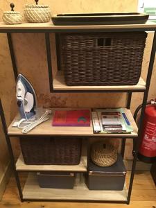 a shelf with wicker baskets and other items on it at Room Feliz in Zele