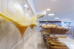 a drink in a martini glass next to baskets of bread at Minura Cala Galdana & Apartamentos d'Aljandar in Cala Galdana
