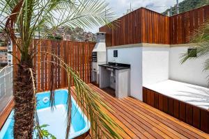 um deque com uma cozinha e uma piscina numa casa em Coberturas Alto Luxo com Terraço, BBQ e Jacuzzi no Rio de Janeiro