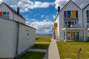 ein Haus und ein Gebäude mit dem Ozean im Hintergrund in der Unterkunft Uns Hüsung in Olpenitz