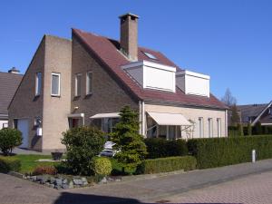 a large brick house with a chimney on top at B&B Korendijk in Zuid-Beijerland