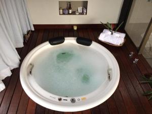 a large bath tub sitting in a bathroom with at Pousada Santa Vila in Serra do Cipo