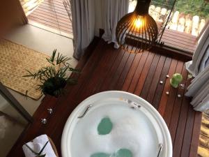 a toilet in a bathroom with a lamp and a window at Pousada Santa Vila in Serra do Cipo