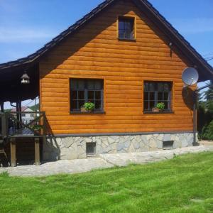 a log cabin with two windows and two plants on it at Domek Socałówka in Sułkowice