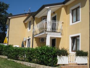 a yellow house with a balcony on it at Apartments Villa Ksenija in Umag