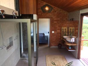 a bathroom with a walk in shower and a sink at Pousada Santa Vila in Serra do Cipo