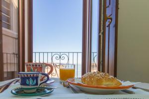 a table with a plate of bread and a glass of orange juice at Residenza Sveva in Termoli