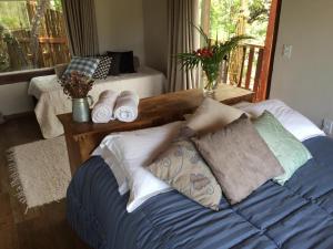 a bedroom with a bed with pillows and a balcony at Pousada Santa Vila in Serra do Cipo