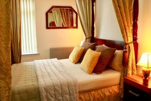 a bedroom with a bed with pillows and a mirror at The Liverpool Pod Travel Hostel in Liverpool