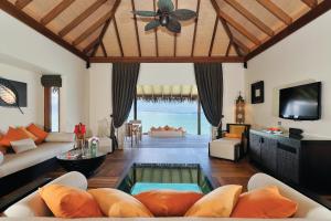 a living room filled with furniture and a tv at Ayada Maldives in Gaafu Dhaalu Atoll