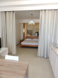 a bedroom with a large bed with white curtains at Villa Alfredo Marchetti Nº13 A Suites on the Beach, Praia de Chaves, Boa Vista in Cabeçadas