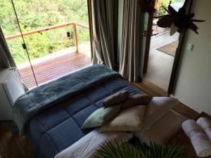 a bedroom with a bed with a view of a balcony at Pousada Santa Vila in Serra do Cipo