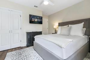 una camera con un grande letto bianco e un armadio nero di St Charles Ave Living Near Hot Spots and Restaurants a New Orleans