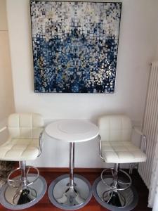 a table and two chairs in a room with a painting at Zagreb Studio 39 Kranjčevićeva in Zagreb