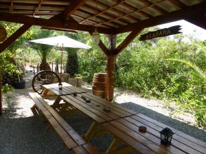 - une table de pique-nique en bois sous un pavillon avec un parasol dans l'établissement Relais de Bravone, à Linguizzetta