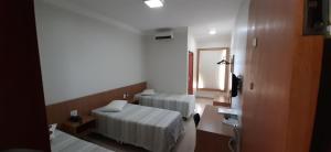 a room with two beds and a window at Guines Palace Hotel in Patrocínio