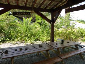 un banco de madera sentado bajo un refugio con una señal en Relais de Bravone, en Linguizzetta