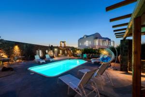 a swimming pool with chaise lounge chairs next to a house at Sakas Residences in Karterados