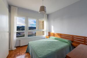 a bedroom with a bed and a large window at Cabo Norte by Staynnapartments in Sopelana