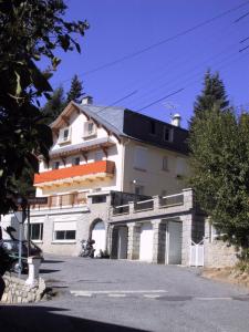 un grand bâtiment blanc avec un parking dans l'établissement Residence Les Cimes, à Font-Romeu