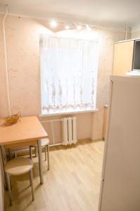 ein Esszimmer mit einem Tisch und einem Fenster in der Unterkunft Apartments in the park area of the Dnipro in Dnipro