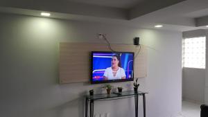 uma televisão numa parede numa sala de estar em Hotel Veneza em Garanhuns