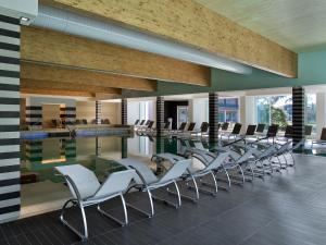 Hotel Mioni Pezzato في أبانو تيرمي: غرفة مع مسبح وكراسي وطاولة