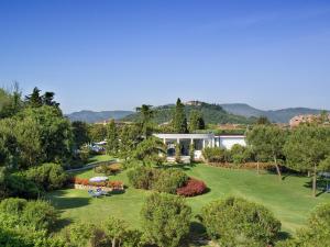 a large house with trees and grass in front of it at Hotel Mioni Pezzato in Abano Terme
