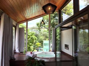 a bathroom with a tub in front of a large window at Pousada Santa Vila in Serra do Cipo