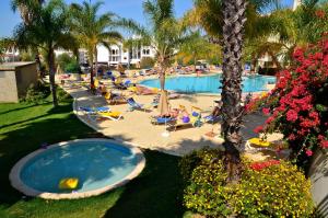 a group of people laying in chairs at a swimming pool at Mirachoro Carvoeiro in Carvoeiro