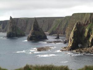 um grupo de grandes rochas na água perto do oceano em Seaview John O Groats Hotel em John o' Groats