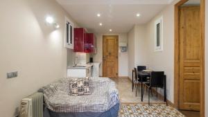 um pequeno quarto com uma cama e uma cozinha em Acogedor apartamento de 2 dormitorios em Barcelona