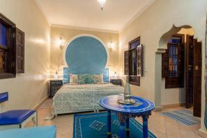 una camera con letto e tavolo di Riad El Walida a Marrakech