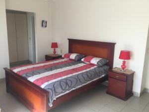 1 dormitorio con 1 cama con 2 mesitas de noche y 2 lámparas en Apartment Manta, next to Hotel Oro Verde, en Manta