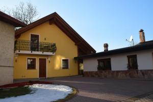 ein gelbes und weißes Haus mit einem Balkon in der Unterkunft Casa Vacanza CADORNA RESIDENCE in Tarvis